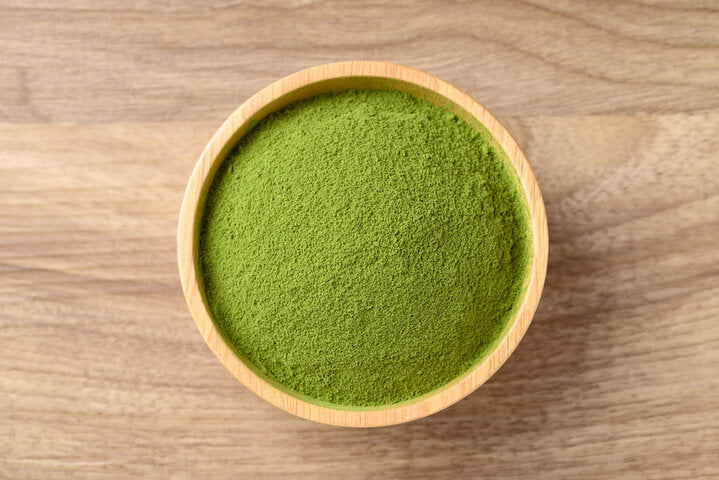 Wooden bowl with fine green matcha powder on wood tabletop — Best Matcha Powder