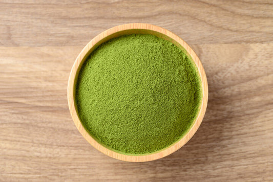 Wooden bowl with fine green matcha powder on wood tabletop — Best Matcha Powder