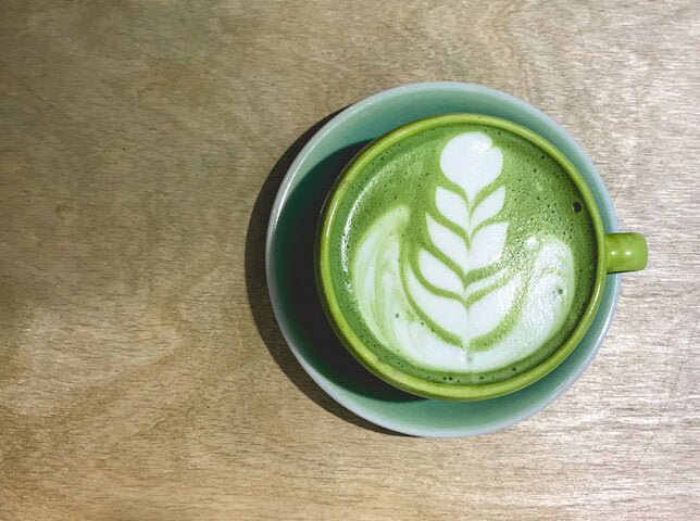 Top-down green latte with leaf latte art in green cup