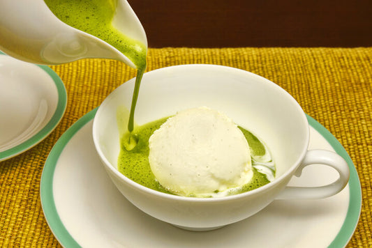 Green matcha drink poured over vanilla ice cream