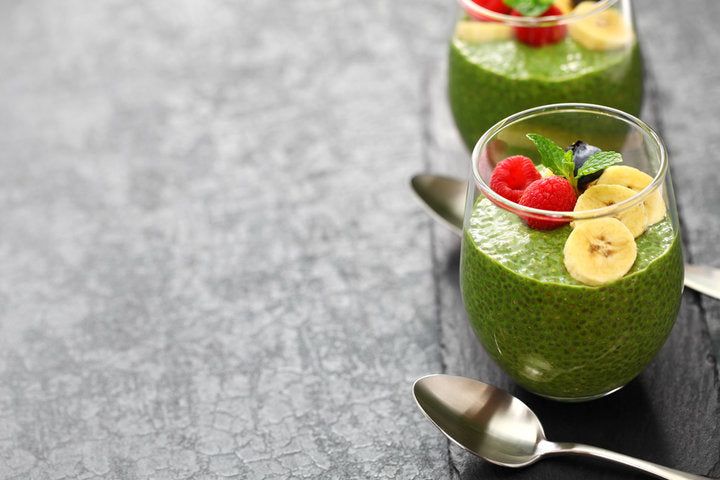 Green pudding cups topped with banana, berries, mint