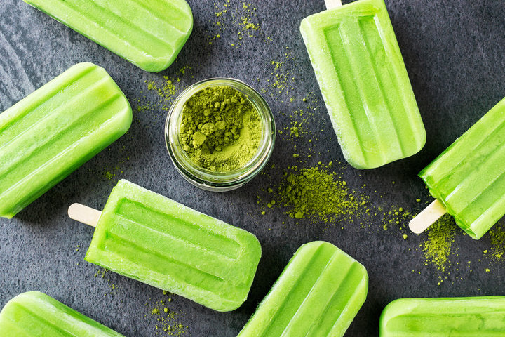 Green popsicles around jar of green powder
