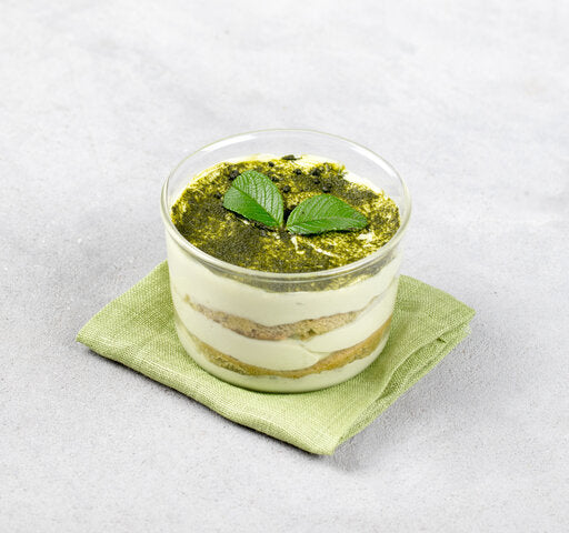 Small glass dessert cup with layered cream and green matcha