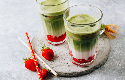 Pink and green layered strawberry matcha latte in clear glass