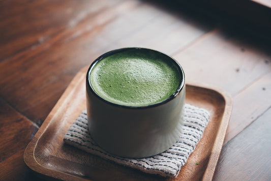 Glass of vibrant green matcha latte with foam — What Does Matcha Taste Like?