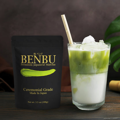 BENBU ceremonial grade matcha 100 g bag next to iced matcha latte on wooden surface